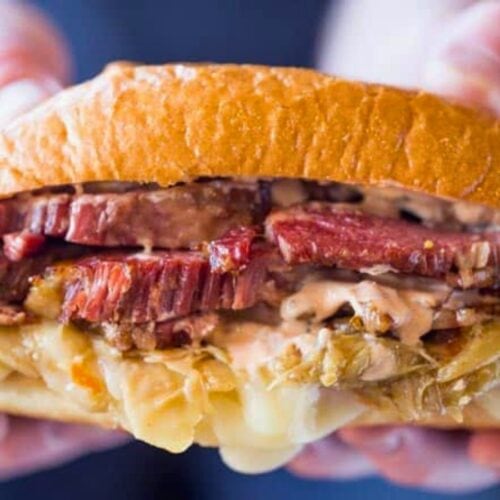 Hands holding up a sandwich with filling visible