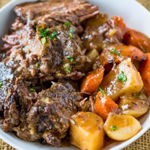 Bowl with portions of cooked roast, potatoes and carrots.