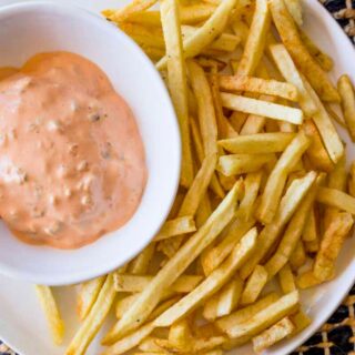 In n Out sauce burger spread in bowl with plate of french fries.