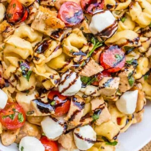 Pasta salad with mozzarella and tomatoes topped with balsamic dressing