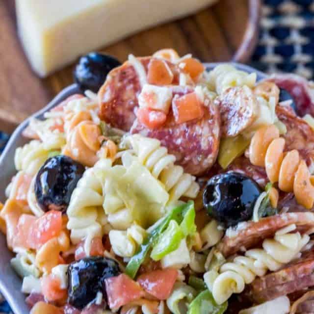 Italian Antipasto Pasta Salad is delicious and easy with creamy Italian dressing, cheese, salami, olives, tomatoes, bell peppers and pasta that's the perfect addition to your summer menus!