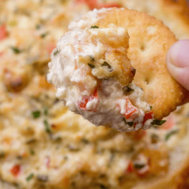 Closeup of dip on a cracker in a bread bowl