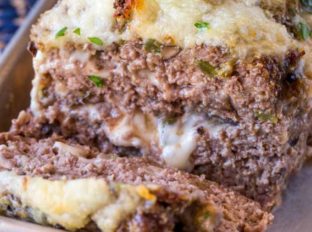 Philly Cheesesteak Meatloaf with green bell bell peppers, onions and mushrooms topped and stuffed with Provolone Cheese.