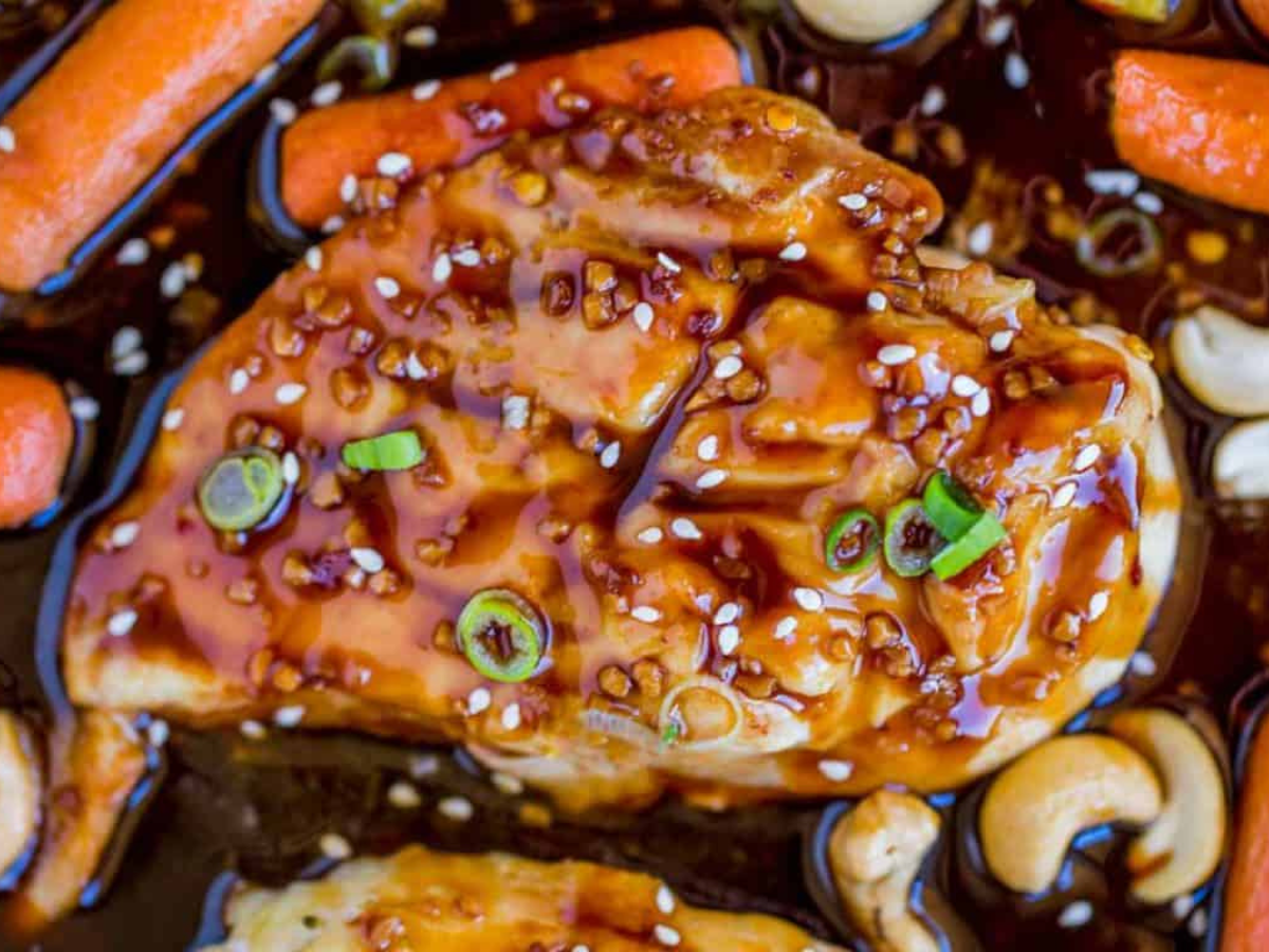 Zoomed in picture of chicken carrots and broccoli on a sheet pan