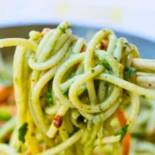 Green curry noodles on chopsticks
