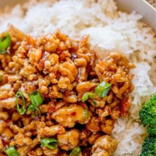 Chicken stir-fry in a bowl with white rice.