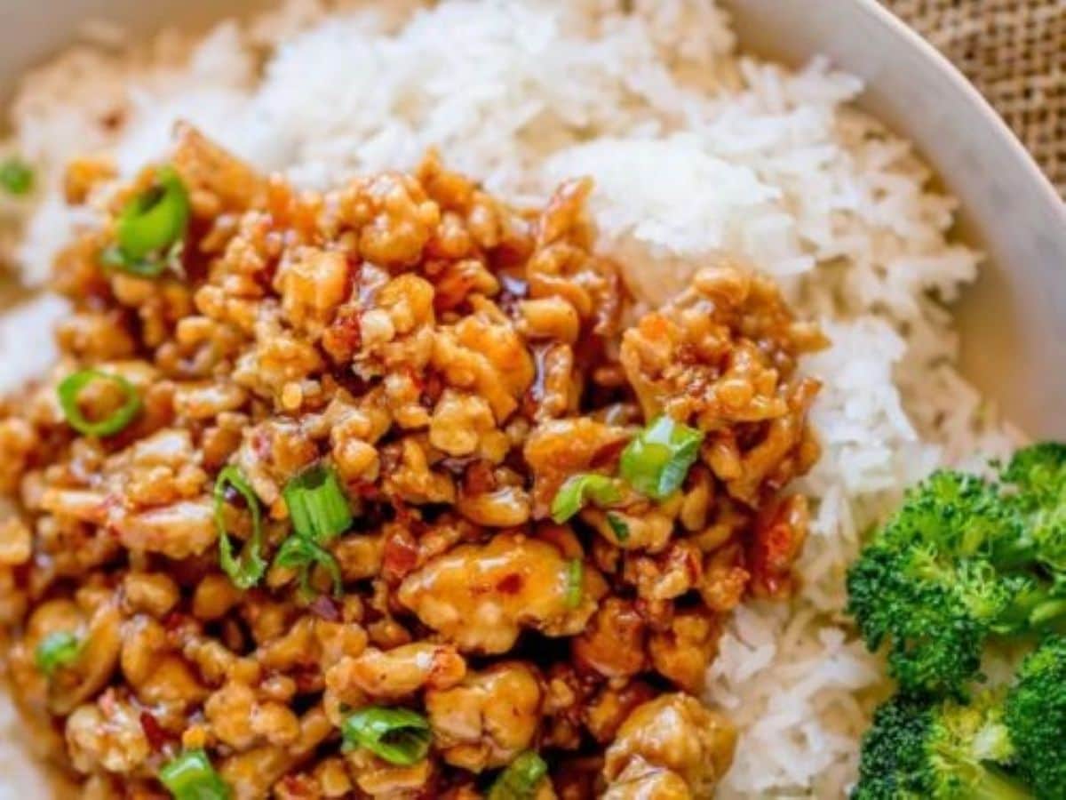 Chicken stir-fry in a bowl with white rice.