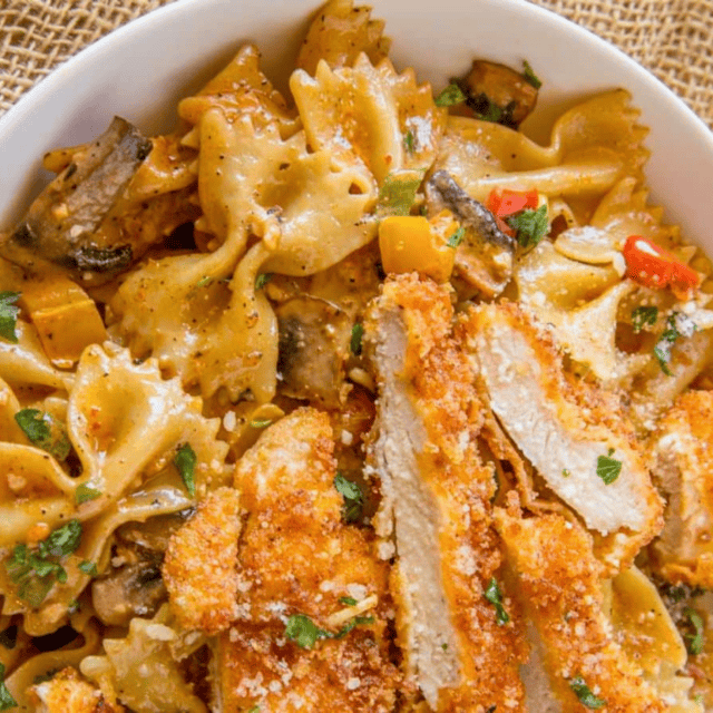 bowl of pasta topped with breaded chicken