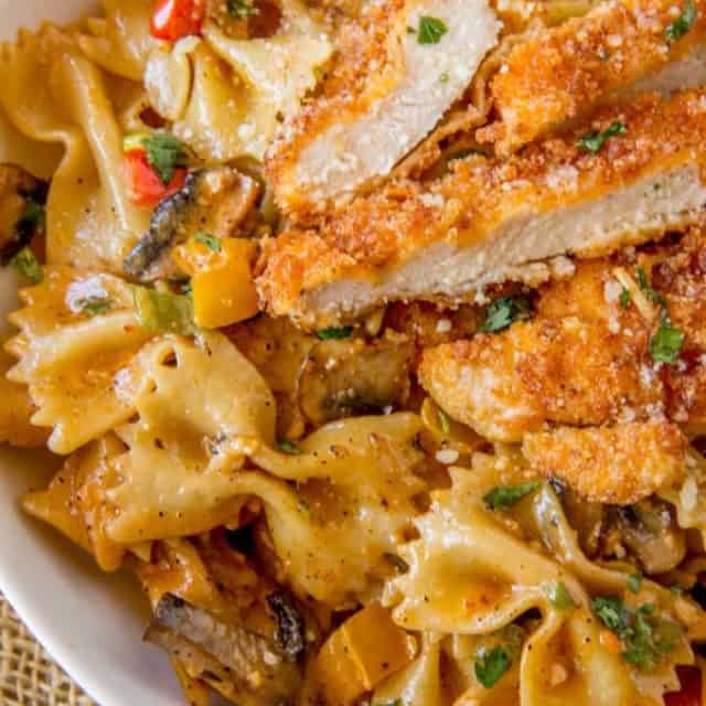 Cheesecake Factory Copycat Louisiana Chicken Pasta with Parmesan, mushrooms, peppers and onions in a spicy cajun cream sauce.