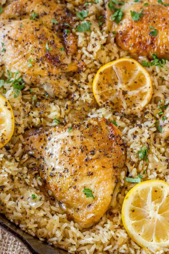 Le poulet et le riz à la grecque à une casserole avec des moitiés de citron rôties est un repas de semaine rapide avec de l'ail, du citron et un riz pilaf assaisonné super savoureux.