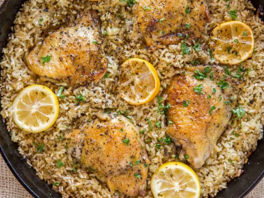 skillet with cooked rice, chicken, and lemon slices