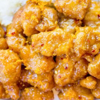 close up of sauced chicken pieces in white bowl