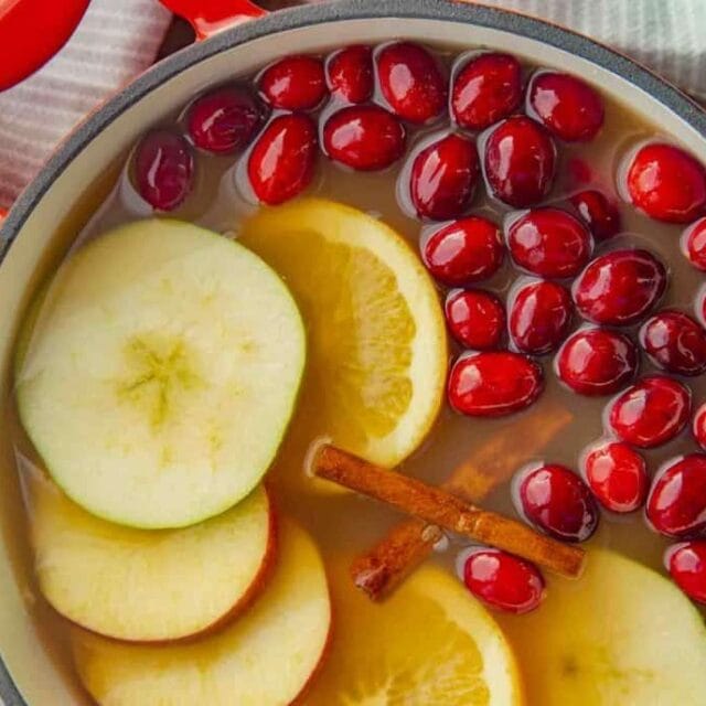 Homemade Cider with cinnamon, apples, oranges, and cranberries in a pot