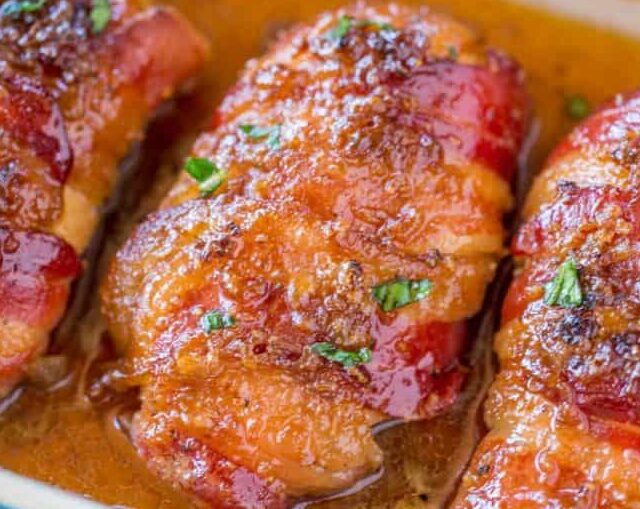 chicken wrapped in bacon in white baking dish