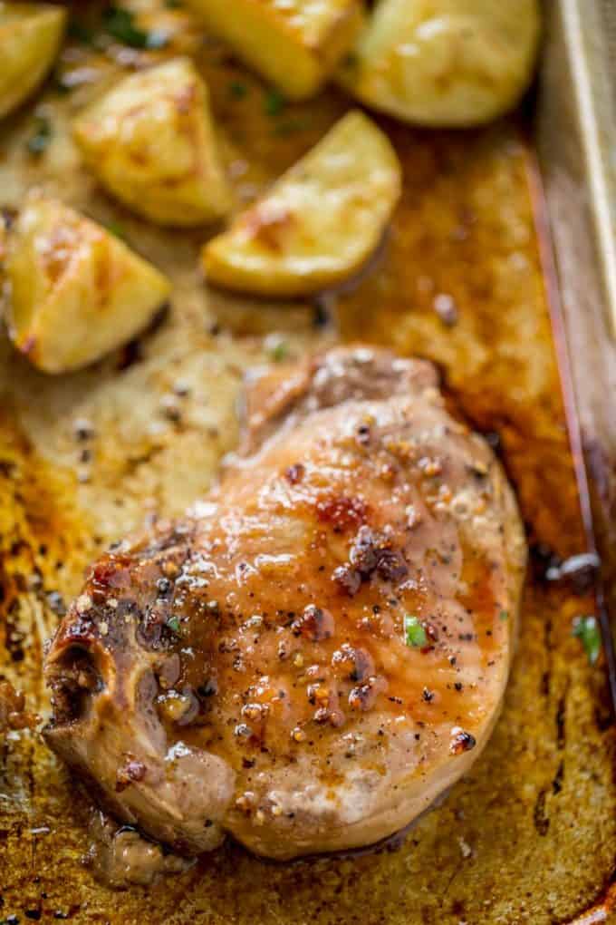 Oven Baked Pork Chops covered in brown sugar and garlic made on a sheet pan with yukon potatoes. One pan, almost no cleanup and the whole family will love them.