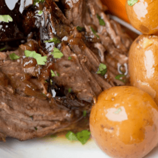 Cooked meat served with potatoes and carrots