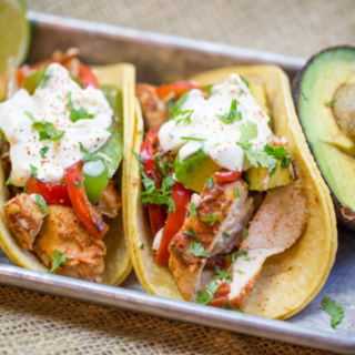 Two tacos on corn tortillas with lime garnishment