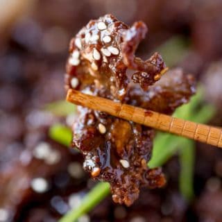 chopsticks with piece of cooked beef 1x1