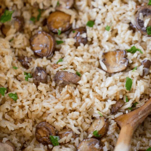 Rice in pan with a wooden spoon