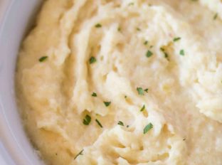 Slow Cooker Mashed Potatoes are an easy side dish (with no boiling required!) that you can make for the holidays and keep warm on the buffet without drying out!