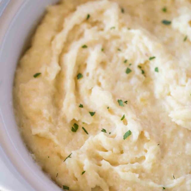 Slow Cooker Mashed Potatoes are an easy side dish (with no boiling required!) that you can make for the holidays and keep warm on the buffet without drying out!
