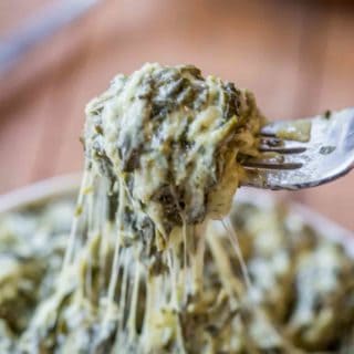 Bite on fork over bowl of creamed spinach.