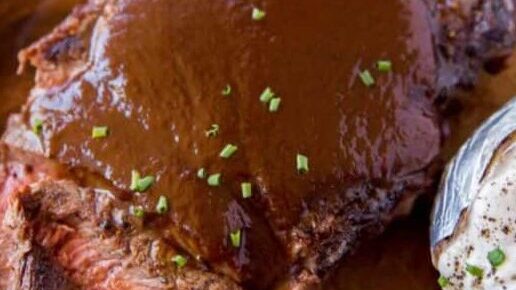 A steak with A1 sauce on a plate with a baked potato.