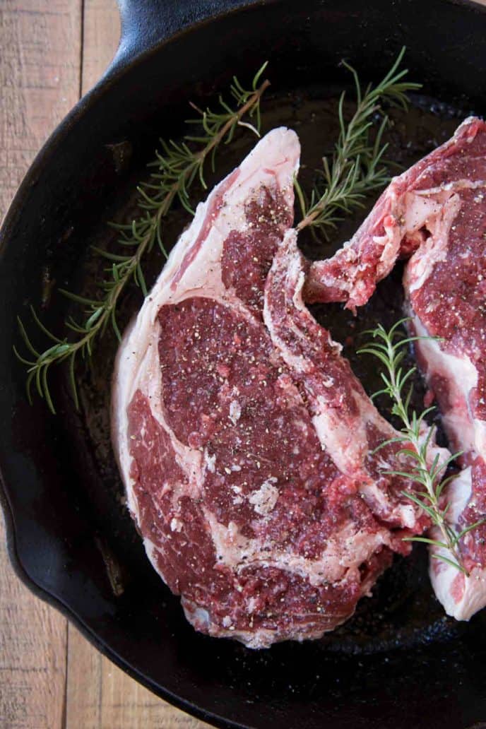 Perfect Thick Cut Ribeye Steak with a large deckle on top of the eye of the steak, cooked in a cast iron skillet.