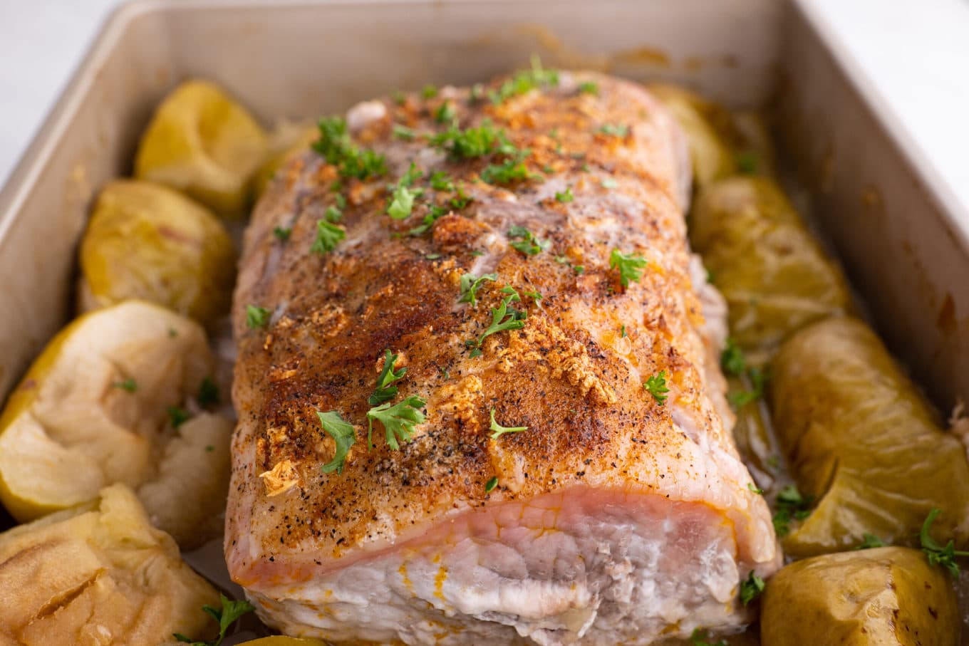 Ultimate Garlic Pork Loin Roast with apples in baking dish