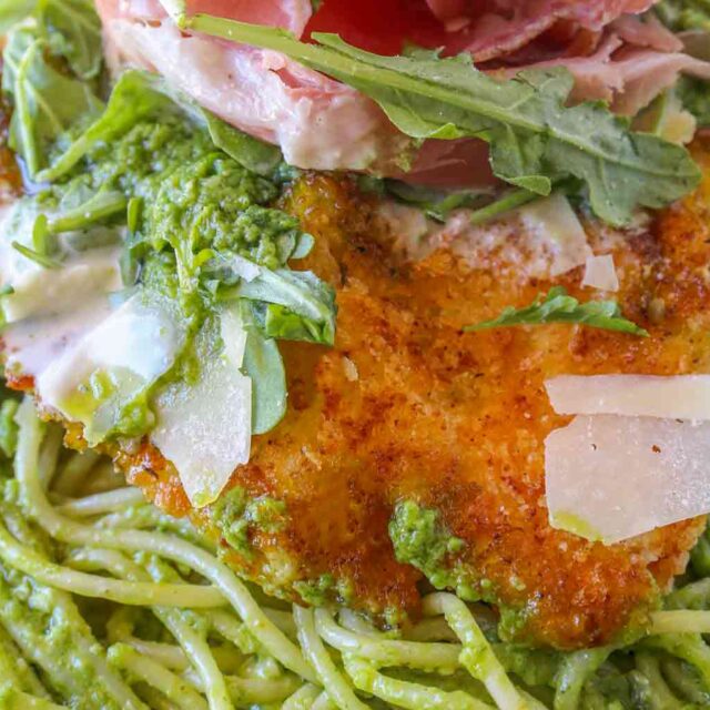 Finished past topped with crispy chicken, greens, and pancetta