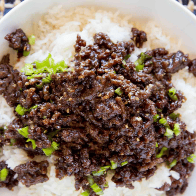 ground beef on top off rice in a white bowl