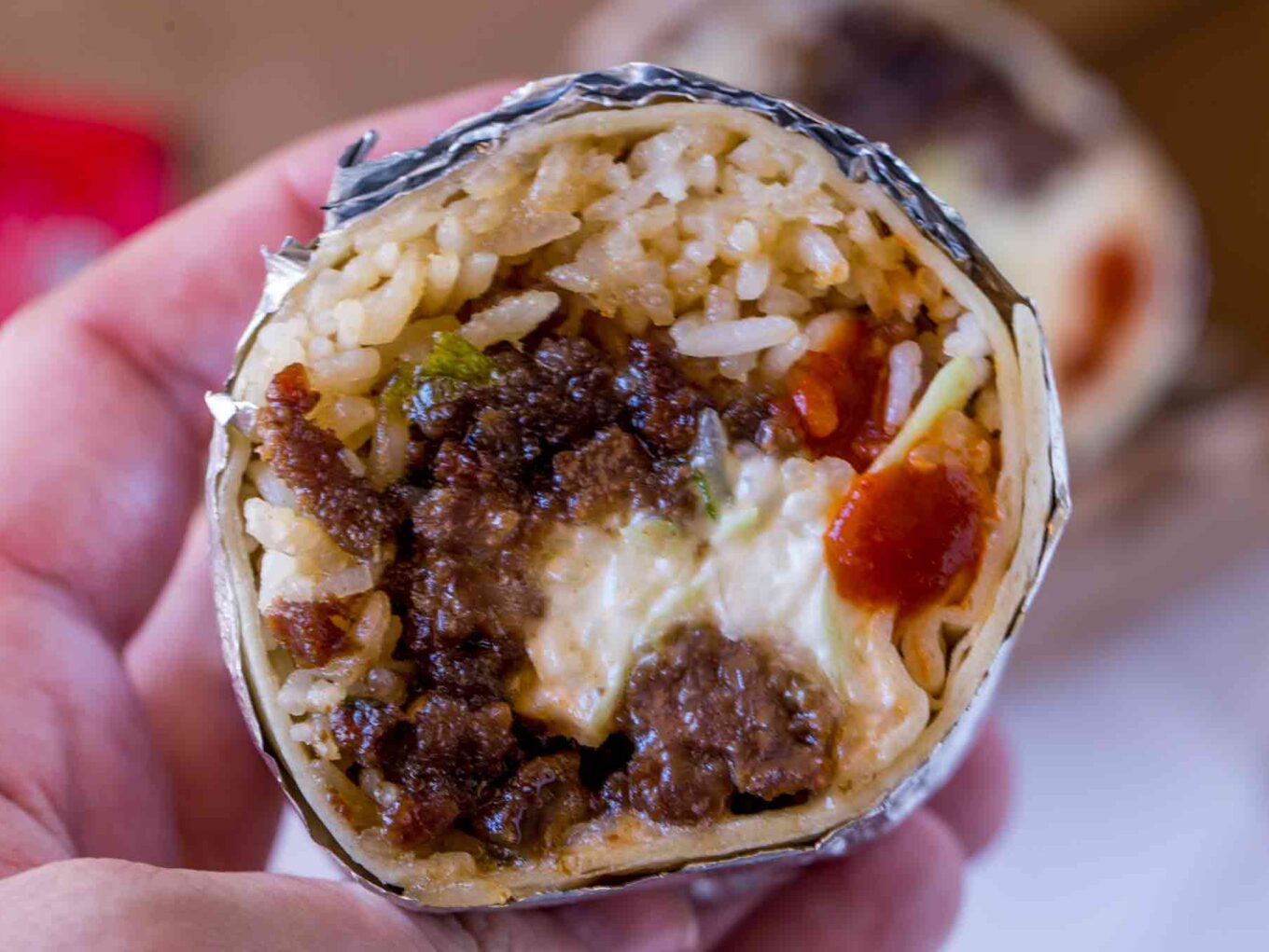 hand holding Burrito cut open