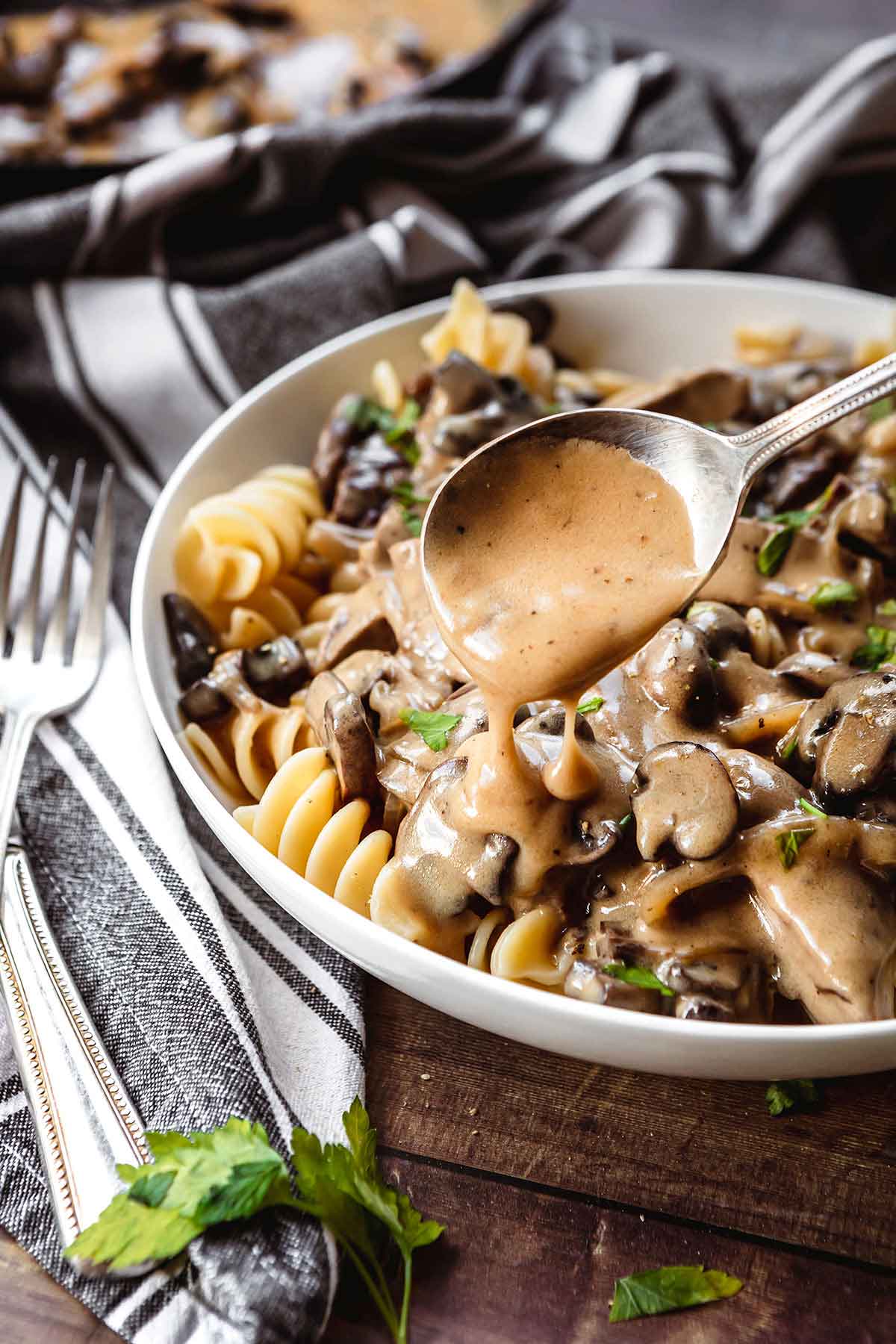 Beef Stroganoff steak with creamy mushroom gravy over egg pasta in bowl