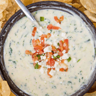 spinach queso in a bowl topped with pico