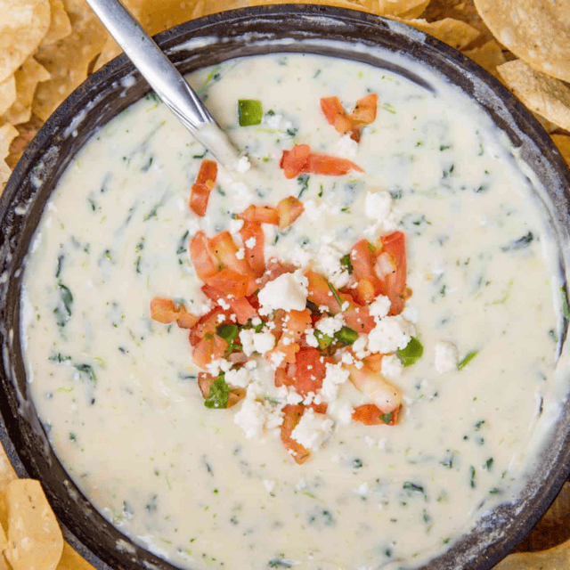 spinach queso in a bowl topped with pico