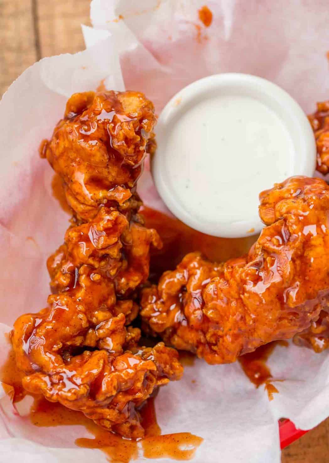 Buffalo Chicken Tenders made with a classic buttermilk soaked extra crispy chicken tender dredged in homemade buffalo sauce. | #buffalochicken #buffalochickentenders #spicybuffalochicken #copycat #chickentenders #chickencrispers #chickenfingers #beerbatteredchicken #chickenstrips #appetizers #gameday #superbowl Buffalo Chicken Strips with ranch sauce