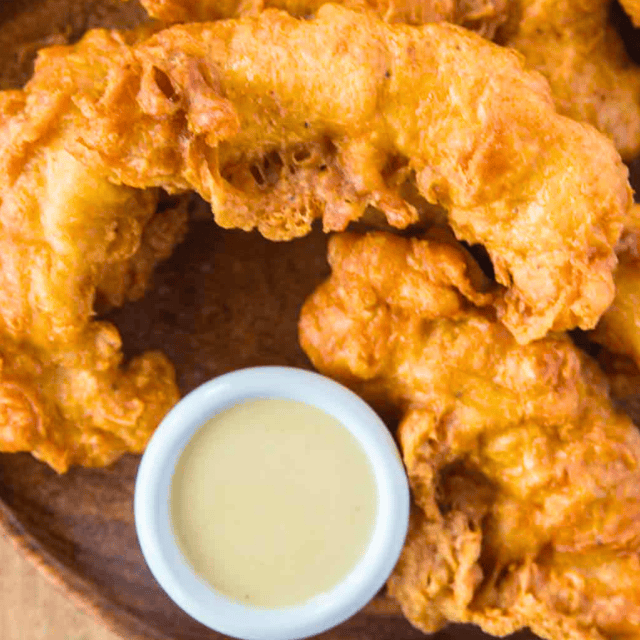 Fried chicken pieces on plate with dipping sauce