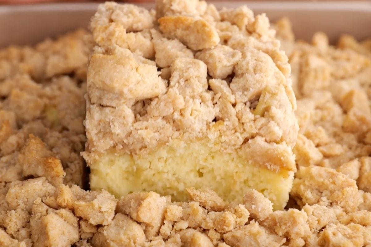 New York Crumb Cake slice lifting from pan