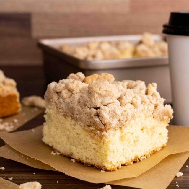 New York Crumb Cake piece on napkin with coffee cup