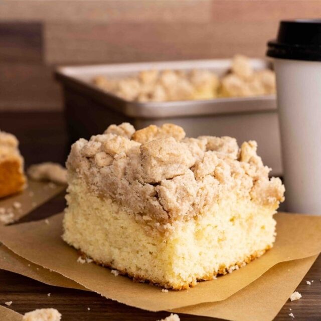 New York Crumb Cake piece on napkin with coffee cup