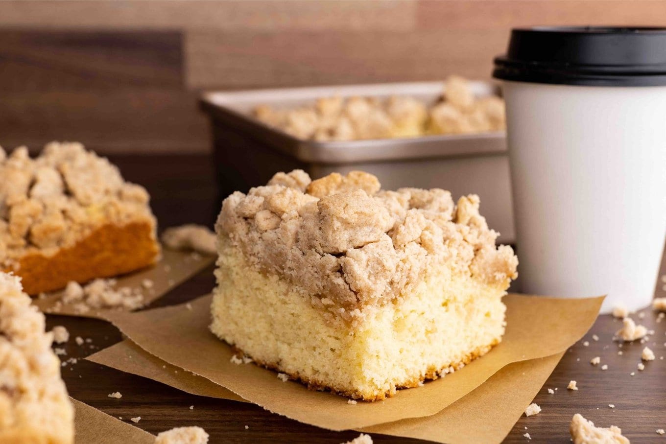 New York Crumb Cake piece on napkin with coffee cup