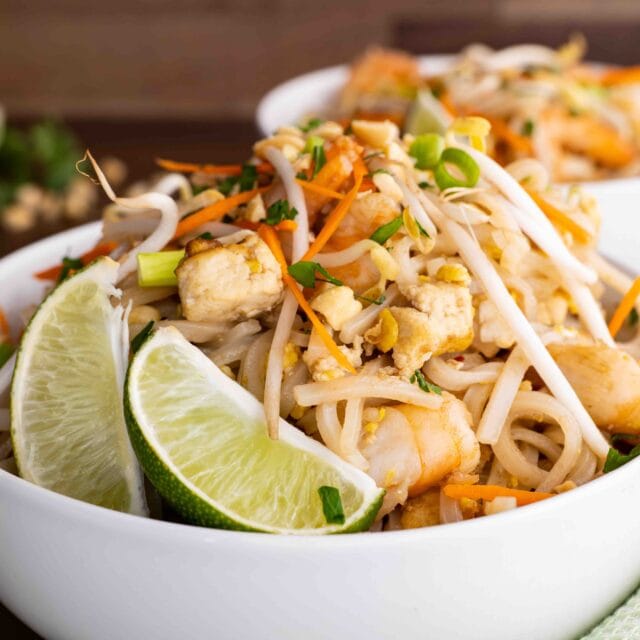 Pad Thai in bowl with lime wedges