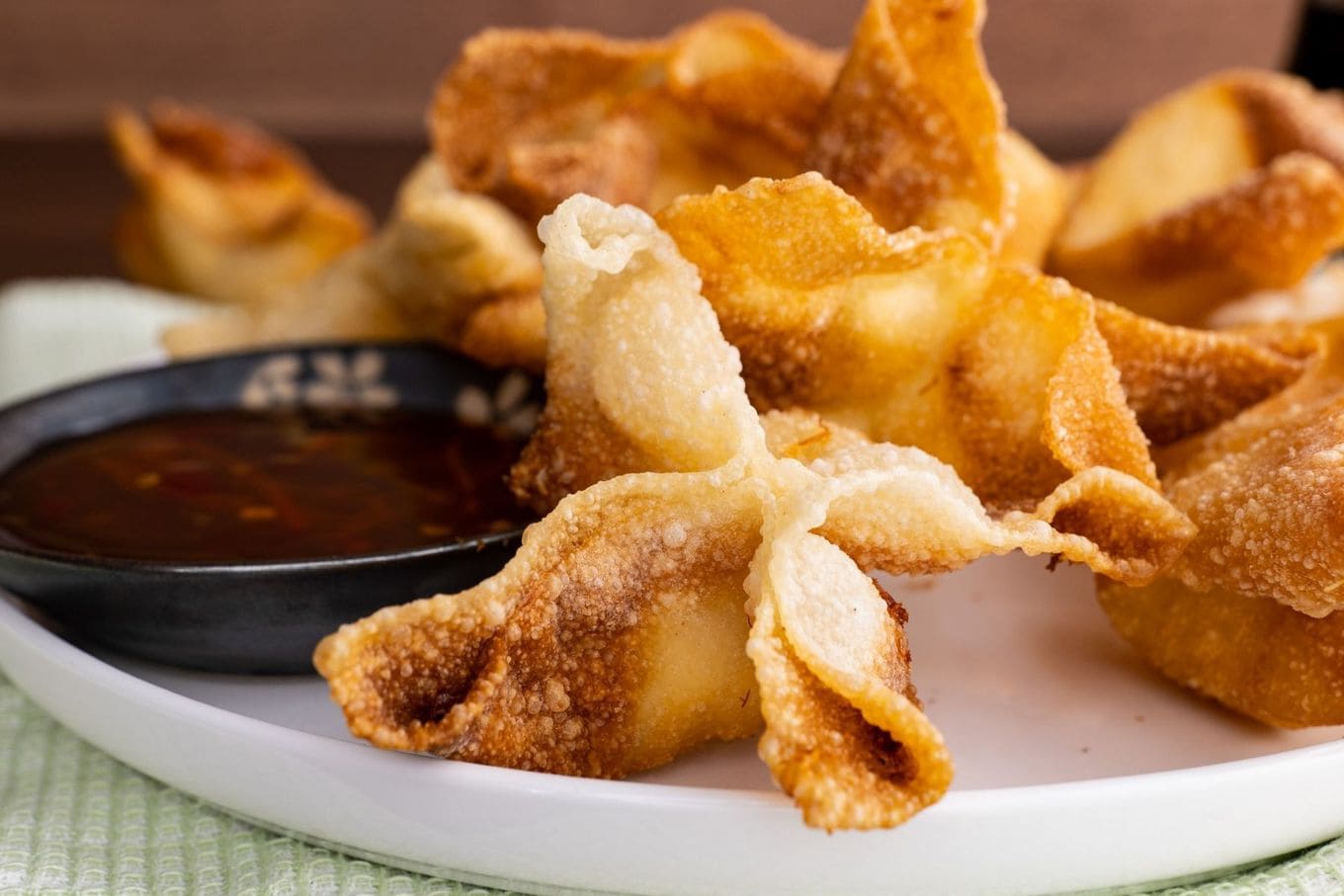 Crab Rangoon on serving plate with dipping sauce