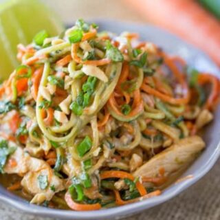 Noodles in a white bowl with a slice of lime.
