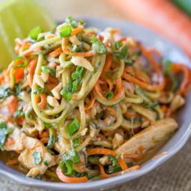 Noodles in a white bowl with a slice of lime.