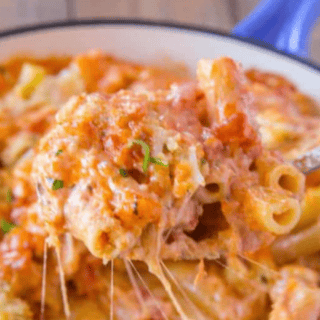 close up of fork taking a bite of cheesy pasta