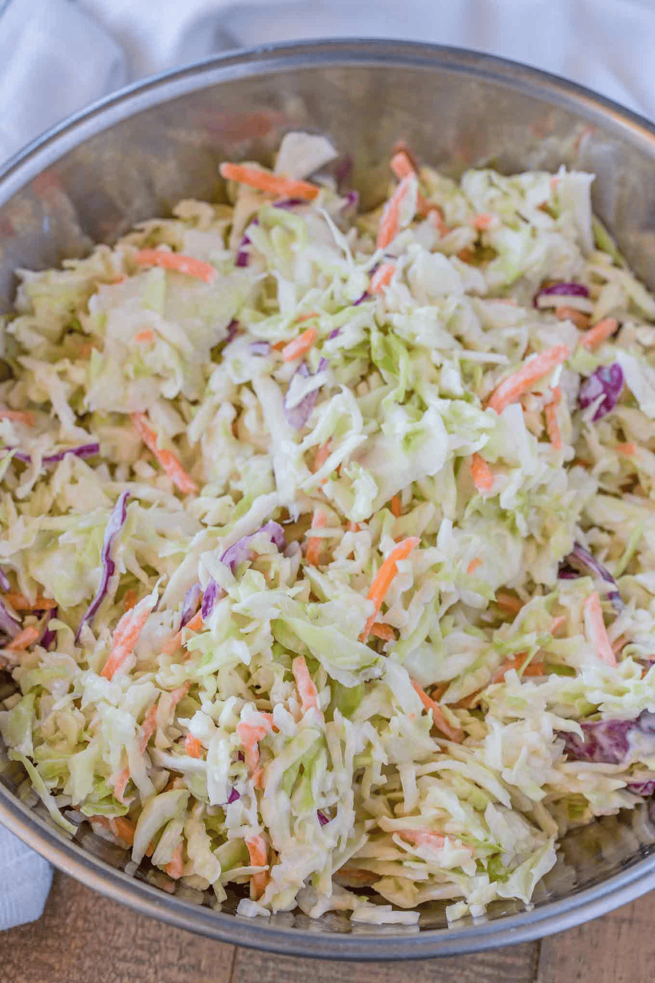 Large metal bowl of dressed slaw