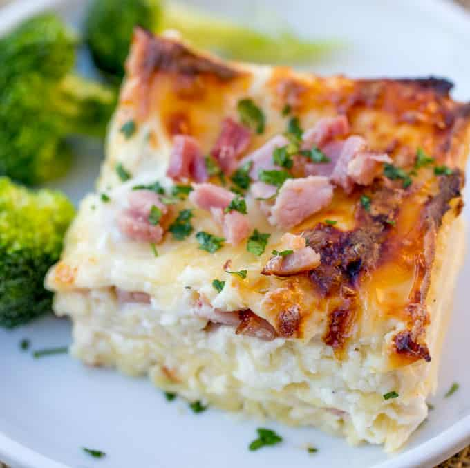 Lasagna served on a plate with broccoli