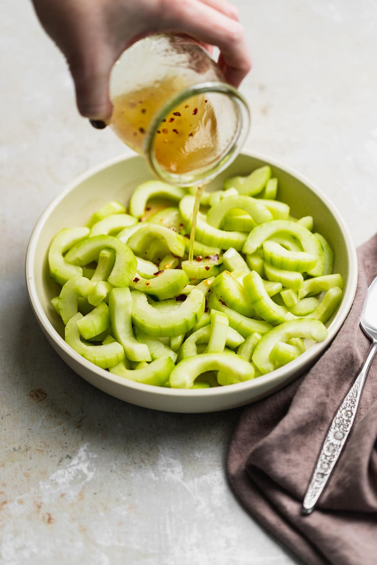 Asian Cucumber Salad pouring on dressing