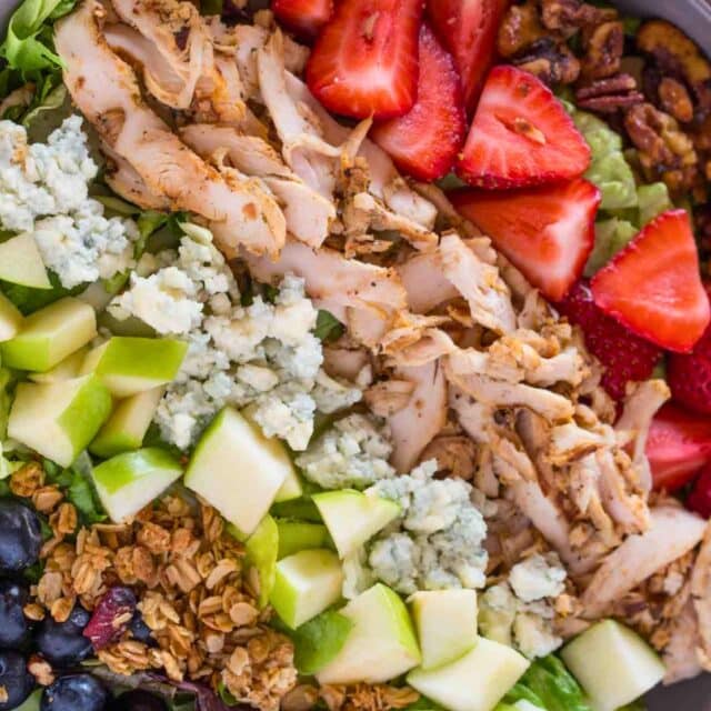 Salad from above with fruits, nuts, cheese, and chicken